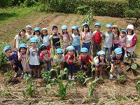 自分たちが苗を植えた菜園で写真撮影